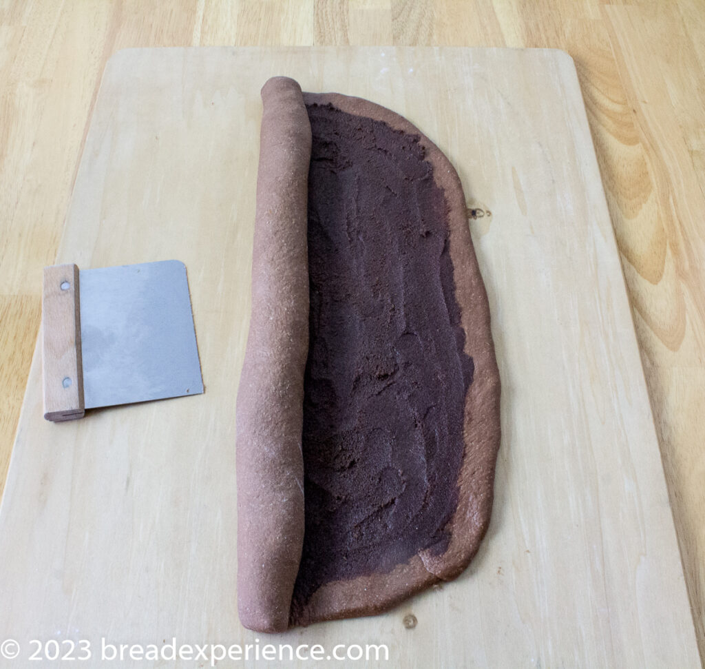 Rolling up the dough for chocolate sweet rolls