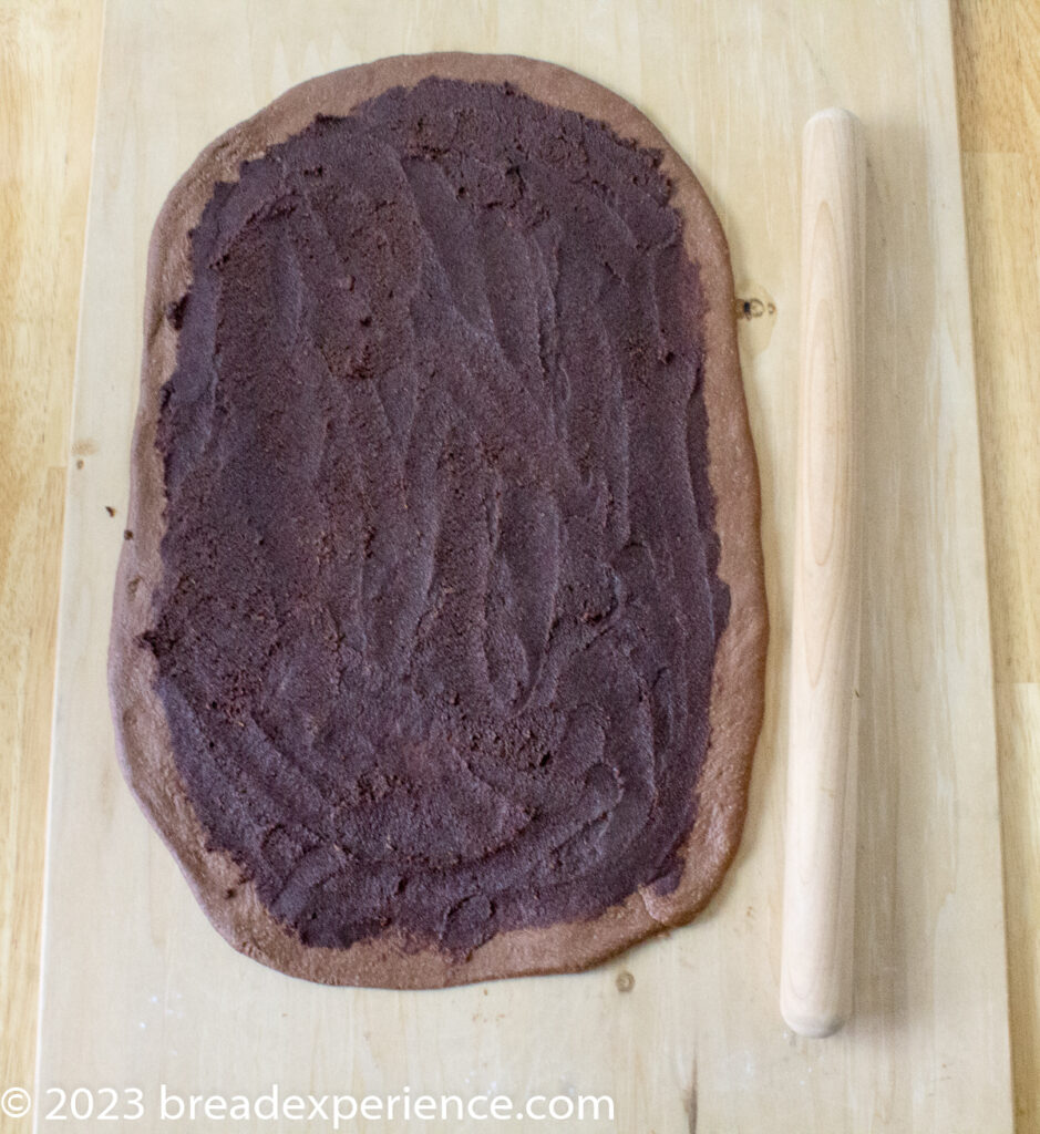 Chocolate sweet roll dough rolled out and spread with chocolate/orange filling